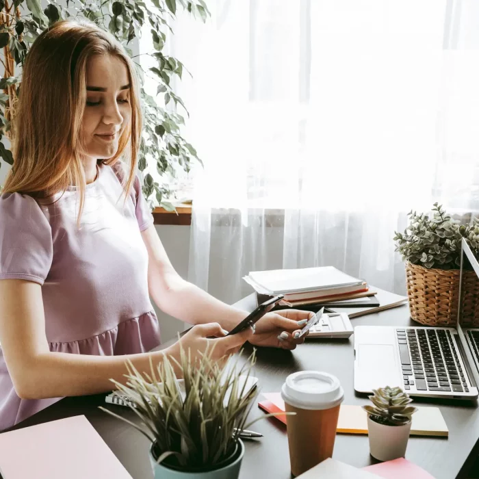 Businesswoman using mobile phone in modern office, close up